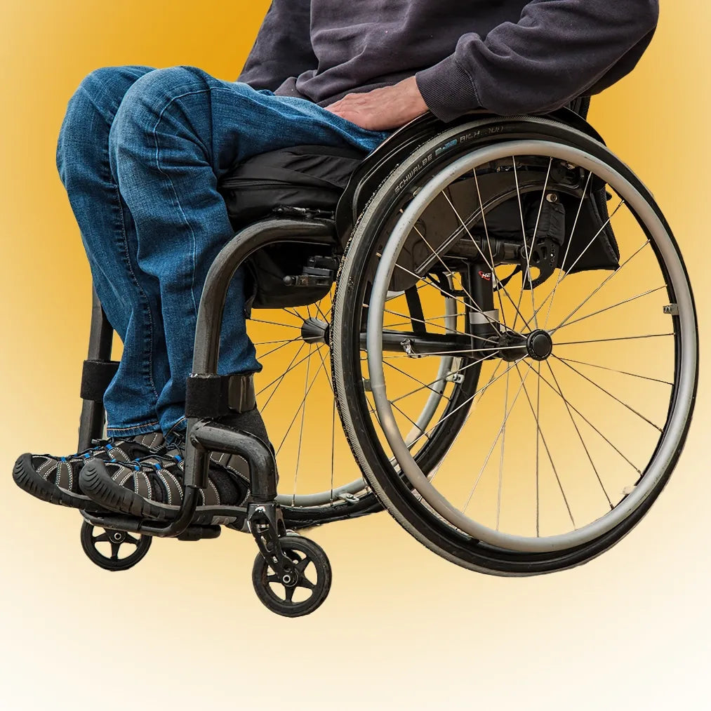 Wheelchair user in a manual wheelchair against a yellow background.