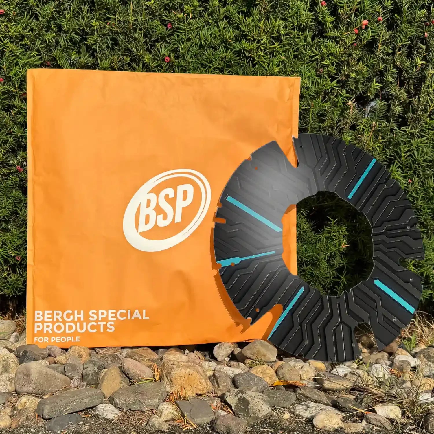 Modern black wheelchair spoke guard with blue accents, displayed outdoors near an orange banner.