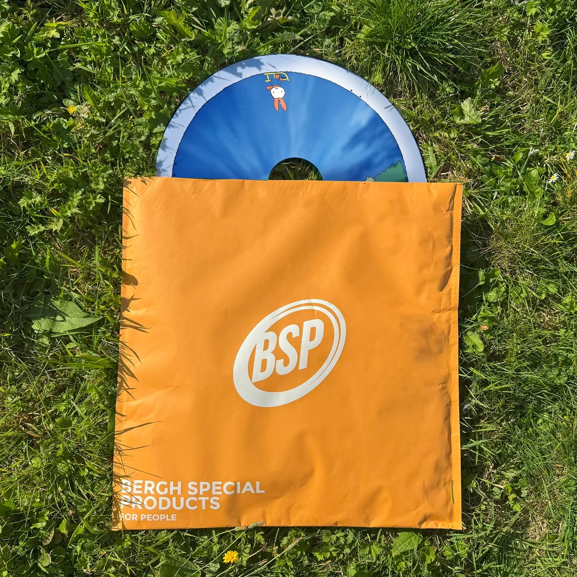 Rollstuhl-Speichenschutz mit Miffy Winter Story Design in orangefarbener BSP-Tragetasche auf Gras