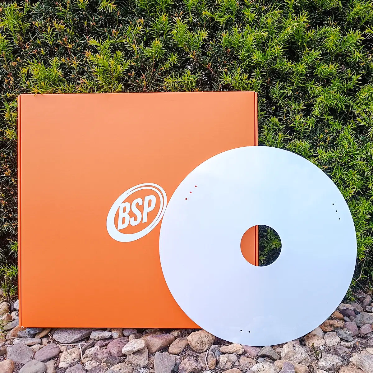 Witte rolstoel spaakbeschermer en oranje BSP verpakking buiten bij groen gebladerte