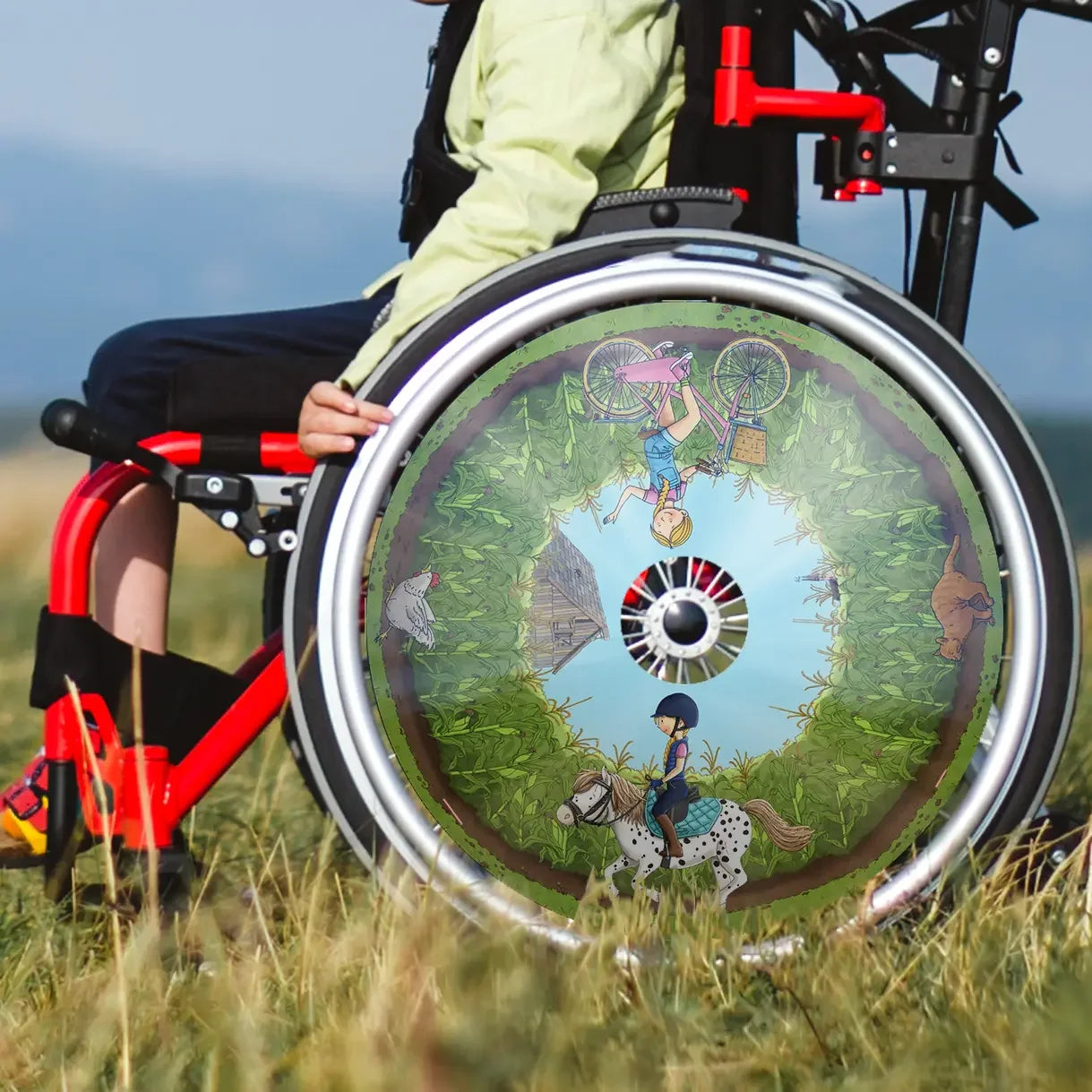 Child in wheelchair with colorful spoke guard featuring pony and cornfield illustration