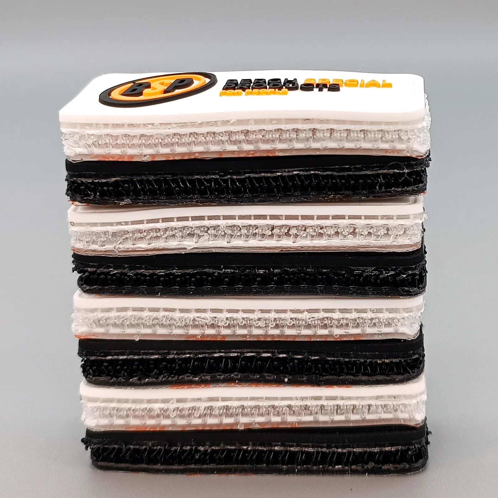 Stacked wheelchair tray samples with textured surfaces and branded top panel for accessibility accessories