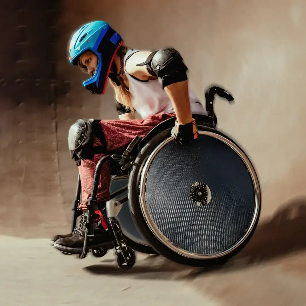 Athlete using wheelchair with carbon fiber spoke protectors and safety gear in motion