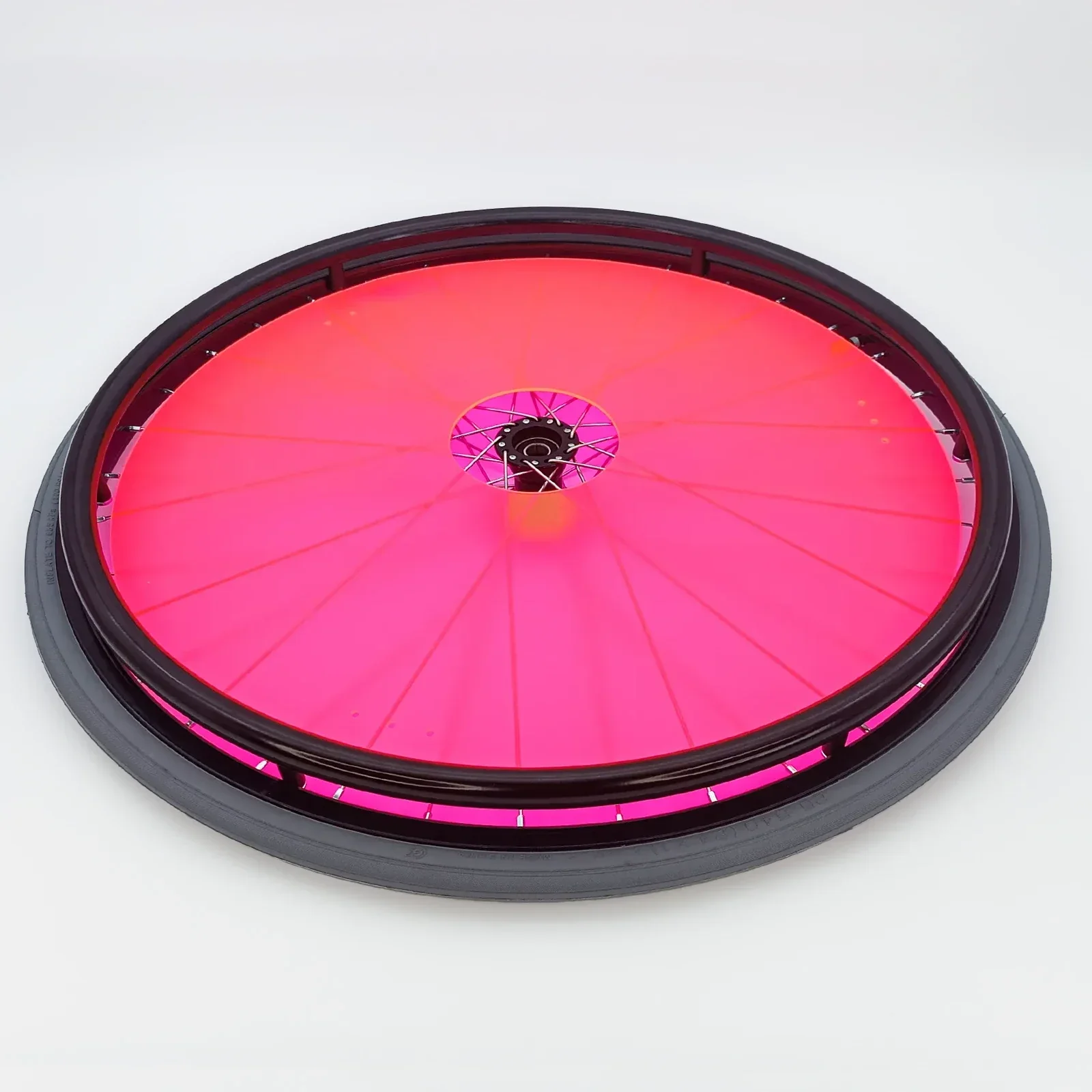 Bright pink wheelchair wheel with black rim and spokes, durable accessory for mobility devices