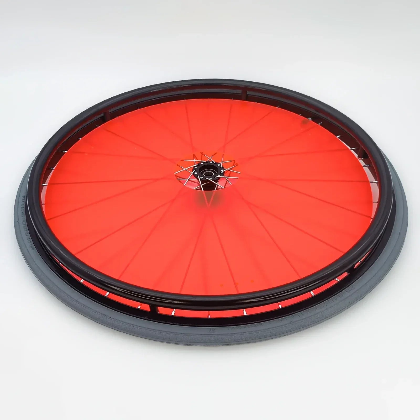 Red wheelchair wheel with black rim and spoke guards, durable mobility accessory for everyday use