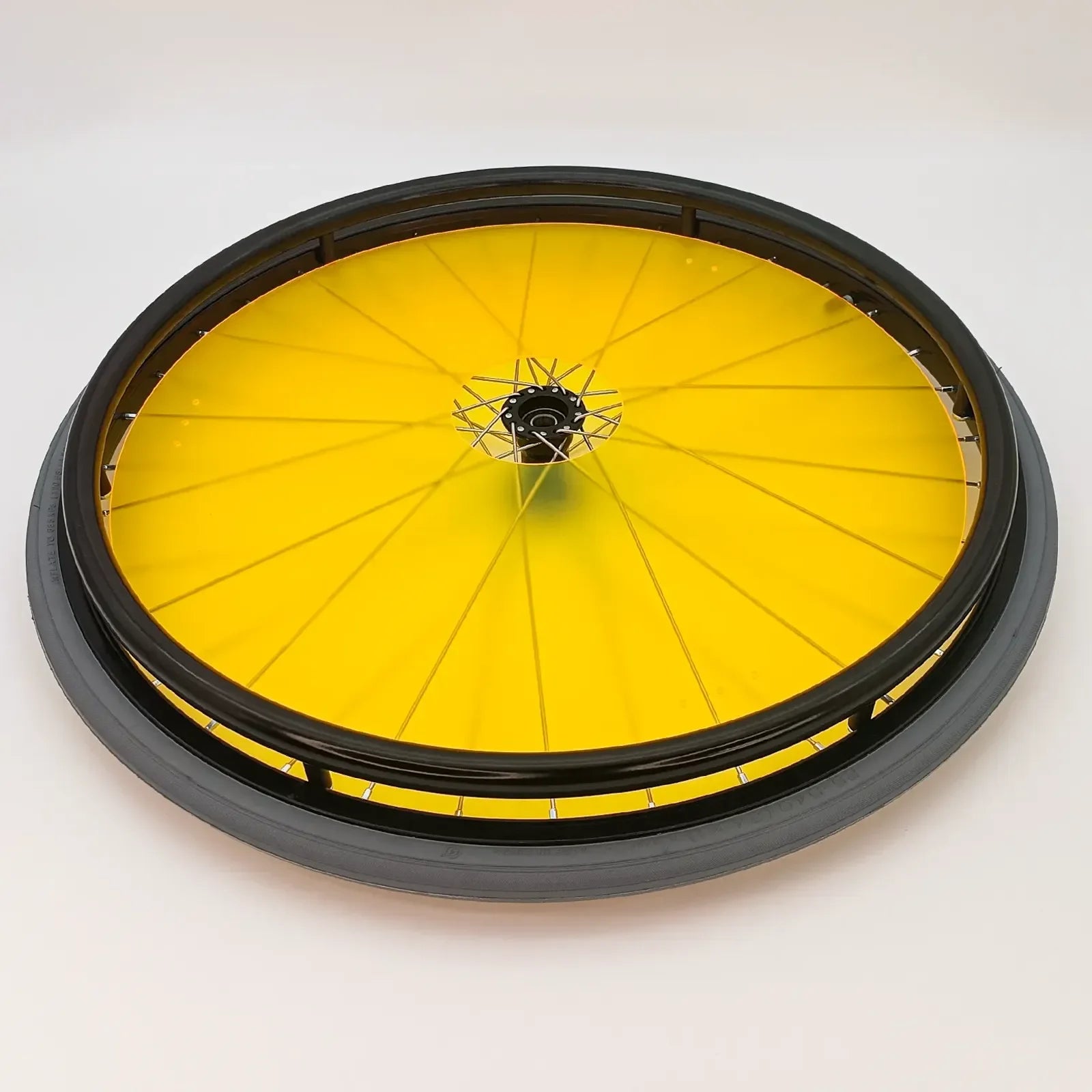 Yellow wheelchair wheel with black rim and spoke guards for mobility accessories