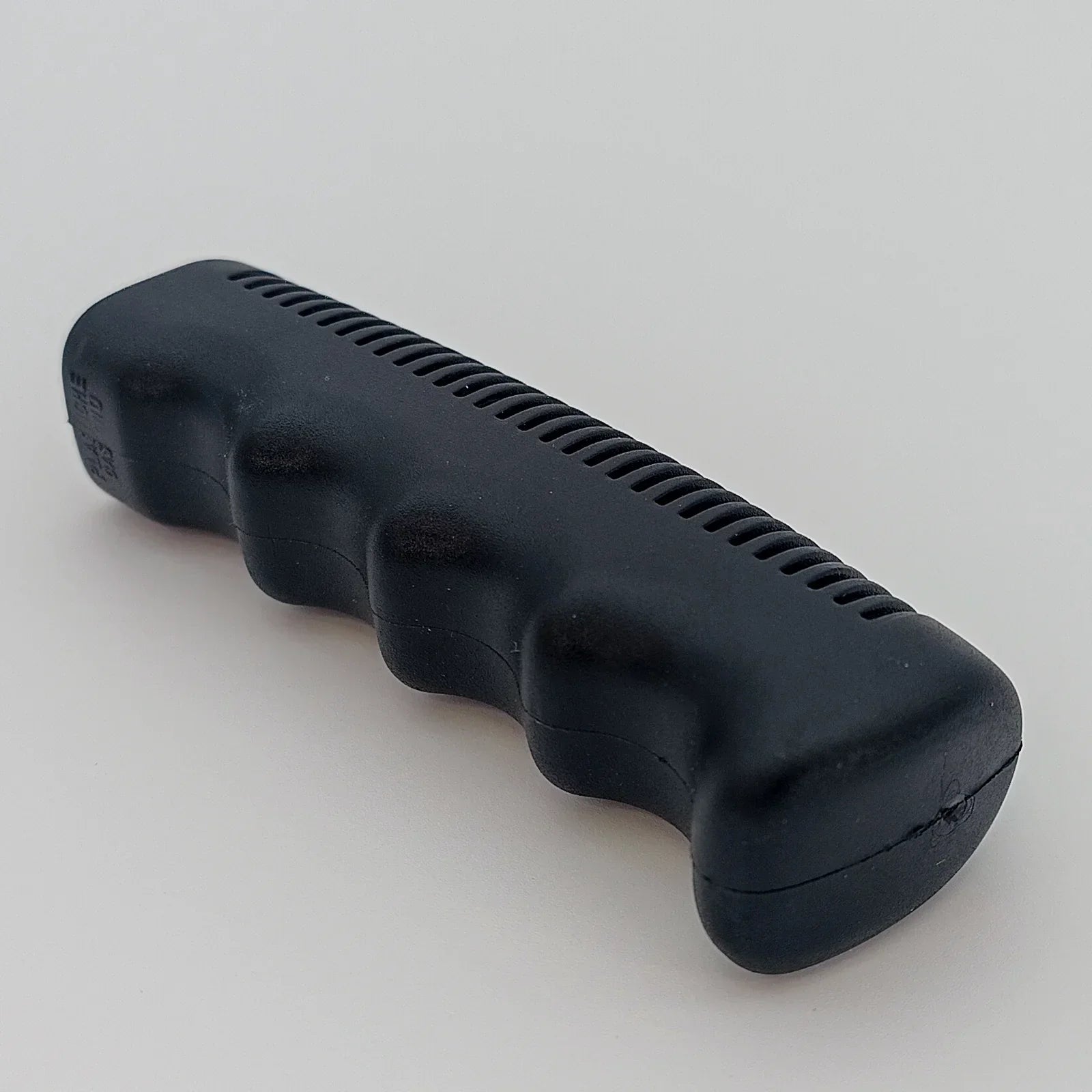 Black ergonomic wheelchair push handle grip with textured surface for secure hold