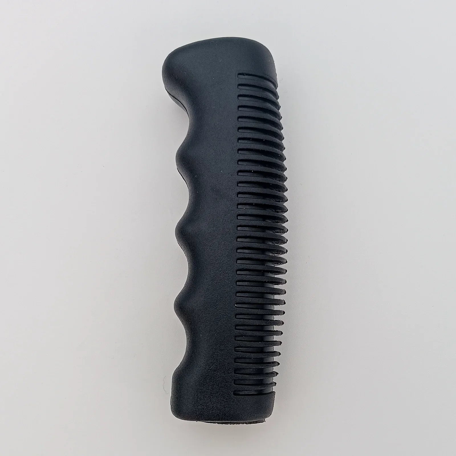 Black ergonomic wheelchair hand grip with textured ridges for secure handling