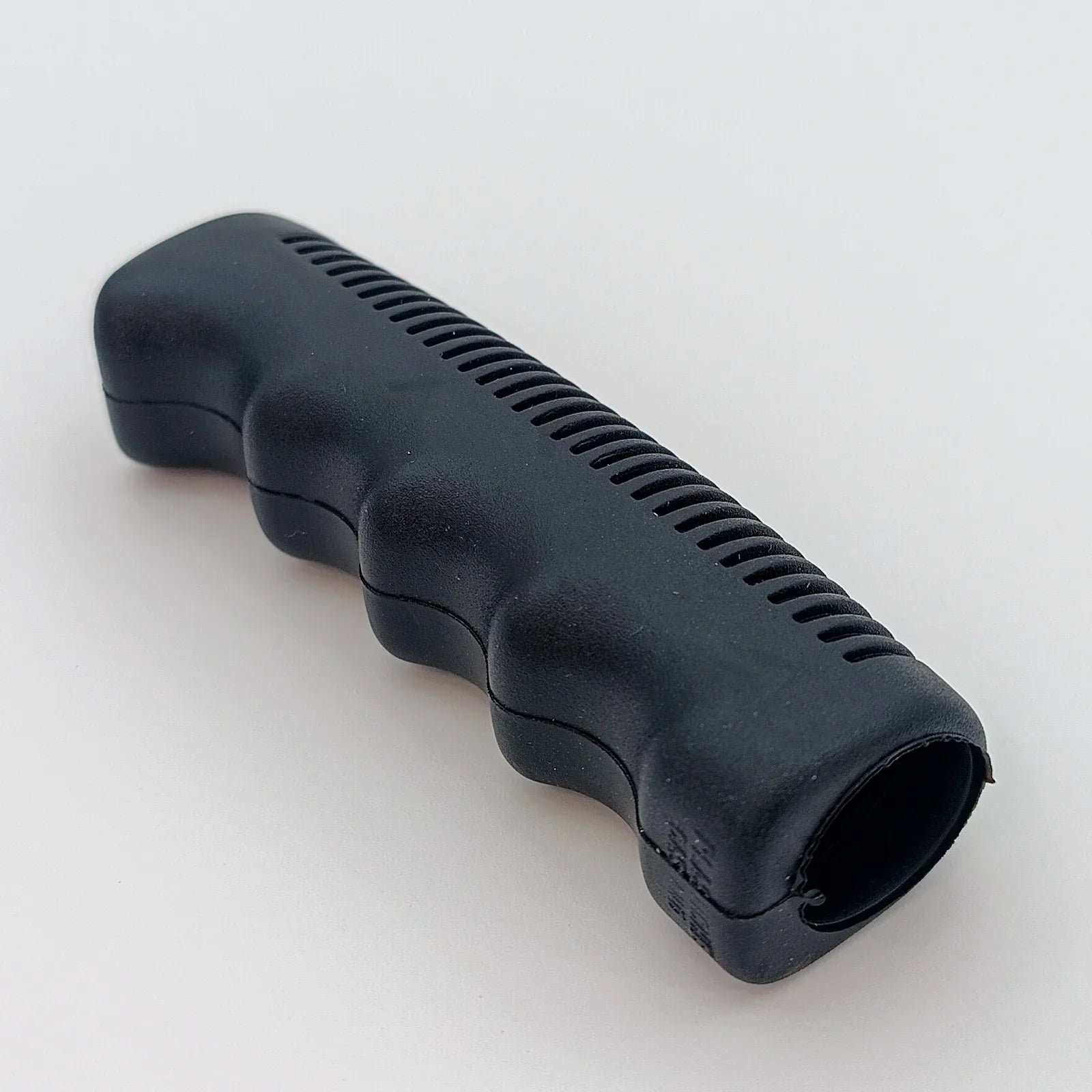 Black ergonomic wheelchair hand grip with textured grip for secure handling