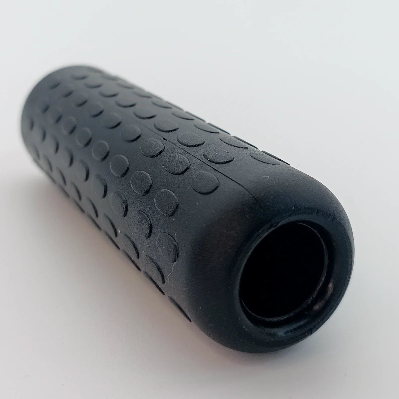 Black textured wheelchair hand grip with ergonomic dot pattern for secure hold and comfort