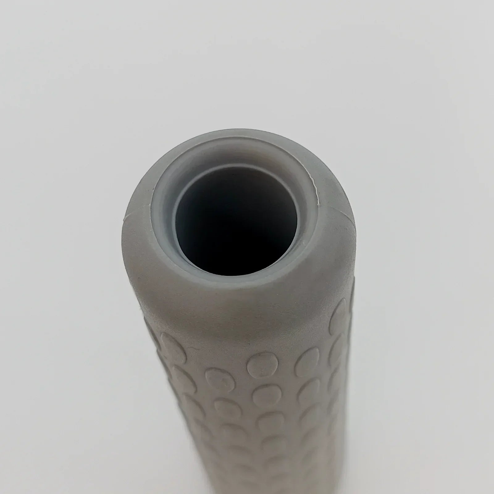 Gray textured wheelchair handle grip with ergonomic dot pattern for secure hold