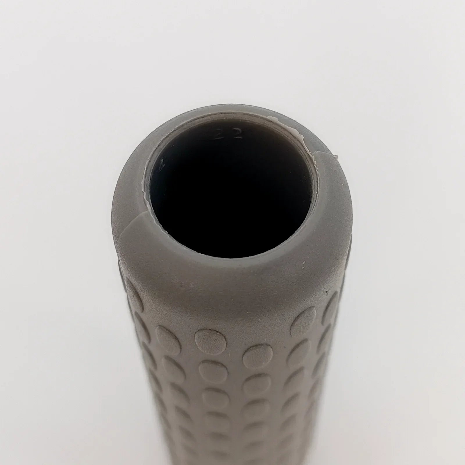 Gray textured wheelchair grip with dotted pattern for secure handling