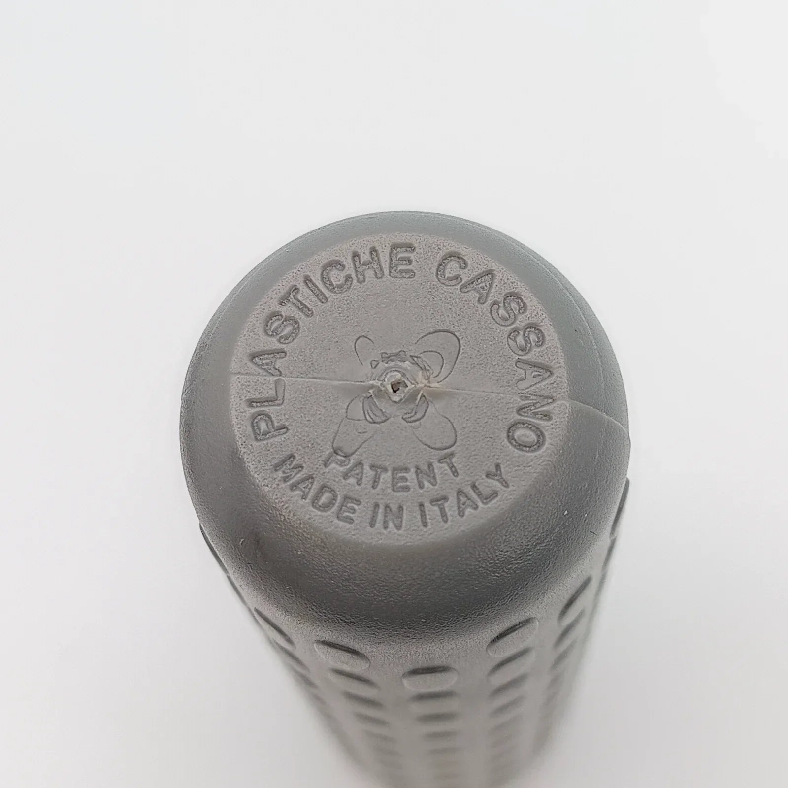 Gray wheelchair grip with textured surface, embossed 'Plastiche Cassano Patent Made in Italy'