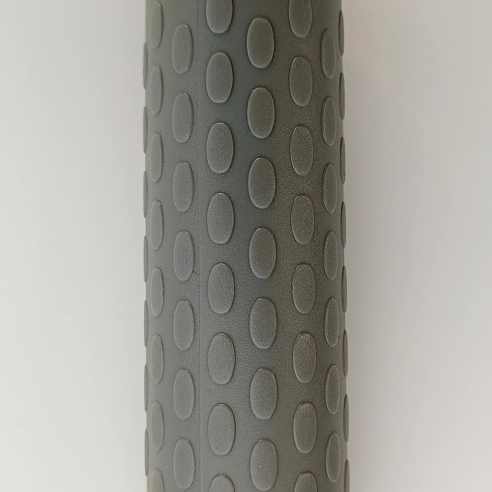Gray textured wheelchair grip with oval patterns for enhanced comfort and control