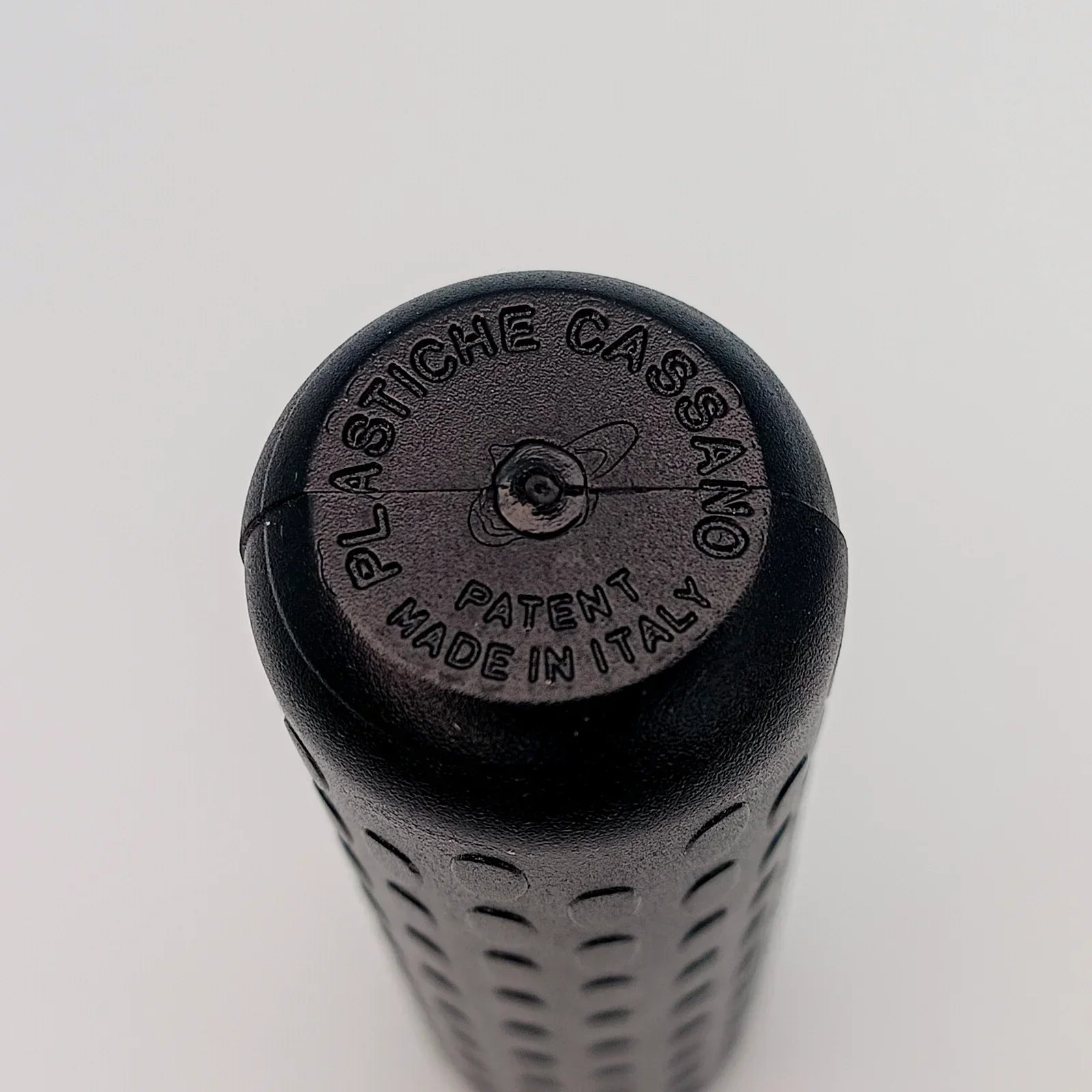 Black textured wheelchair grip with 'Plastiche Cassano Patent Made in Italy' embossed, durable wheelchair accessory