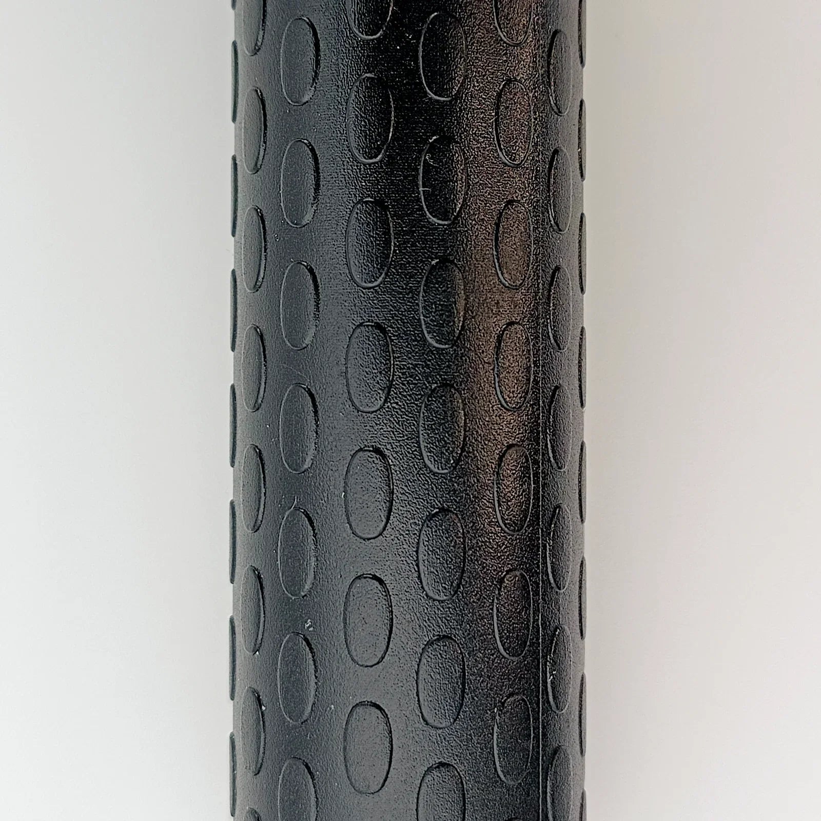 Black textured wheelchair grip with oval patterns for secure handling