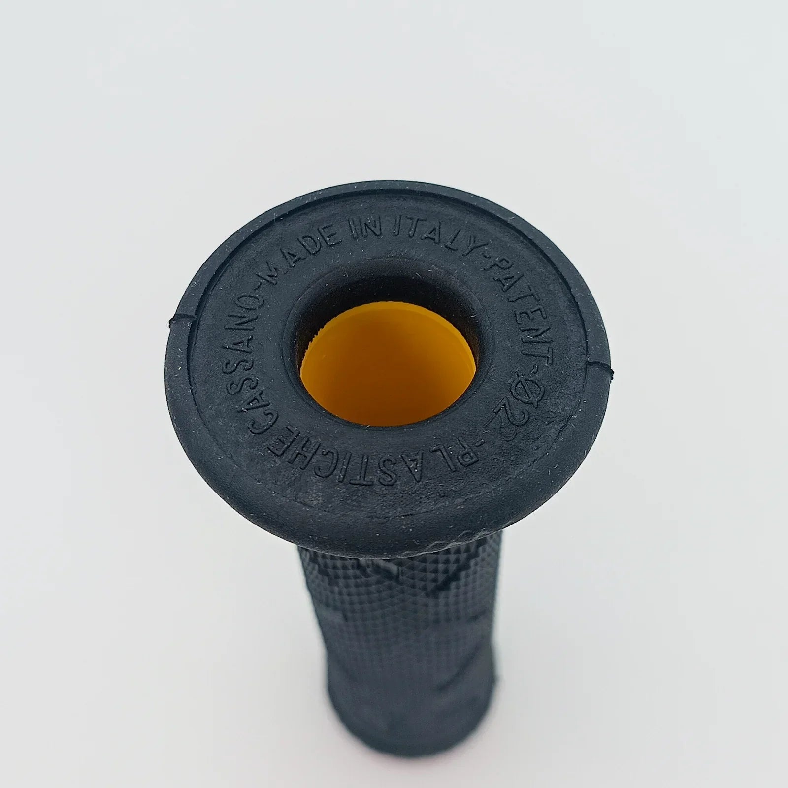 Black wheelchair handle grip with textured surface and yellow interior, made in Italy for durable mobility use