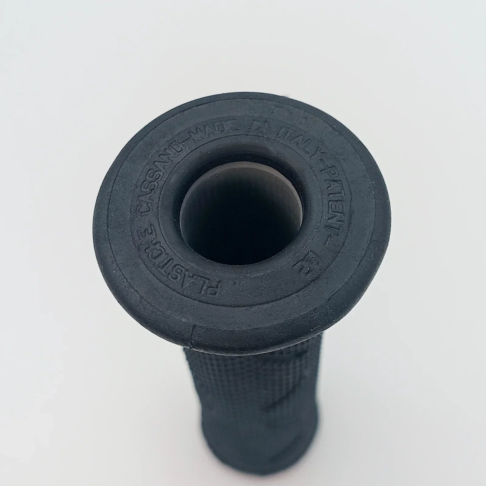 Black wheelchair hand grip with textured surface and embossed text, durable accessory for mobility equipment