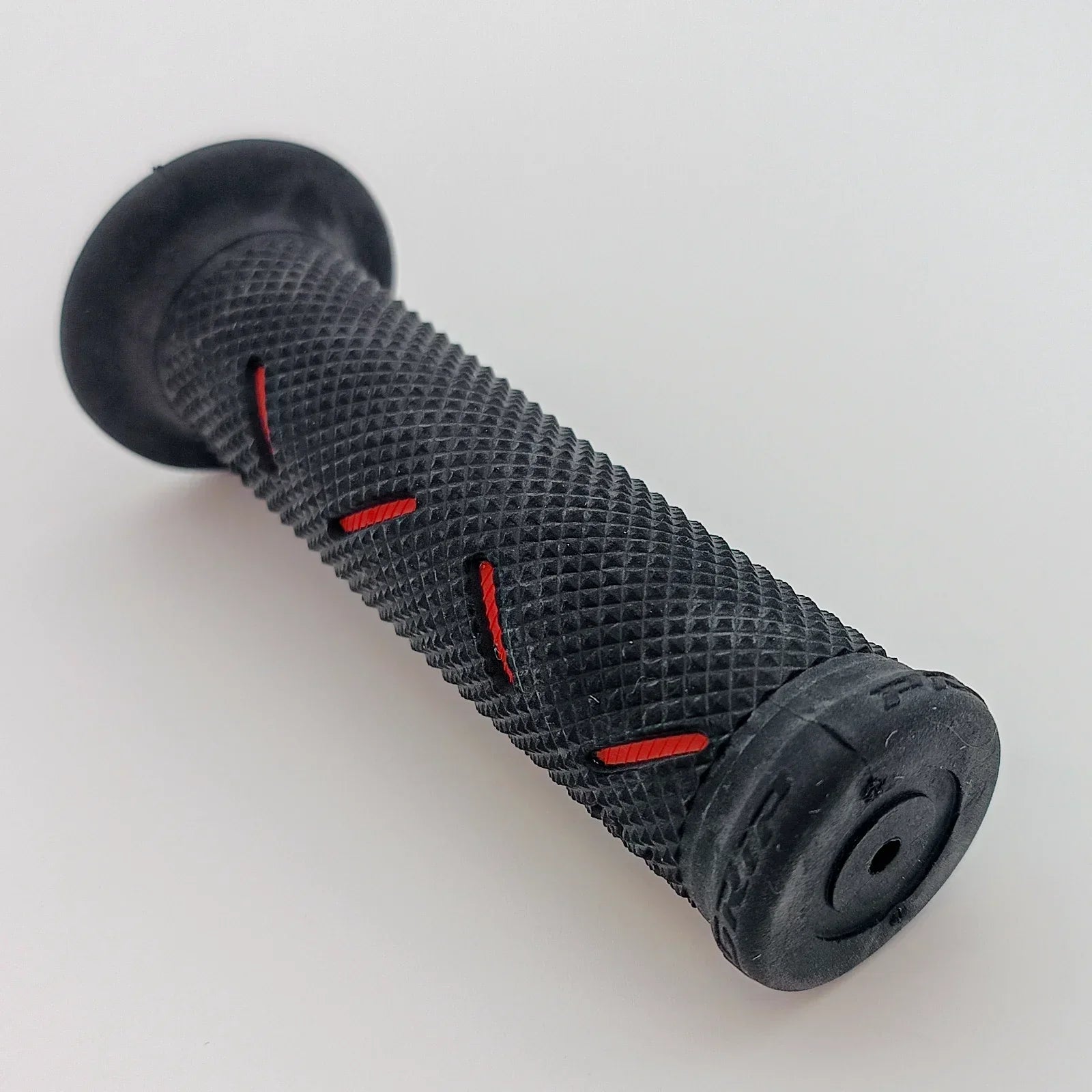 Black textured wheelchair hand grip with red accents for secure push rim control