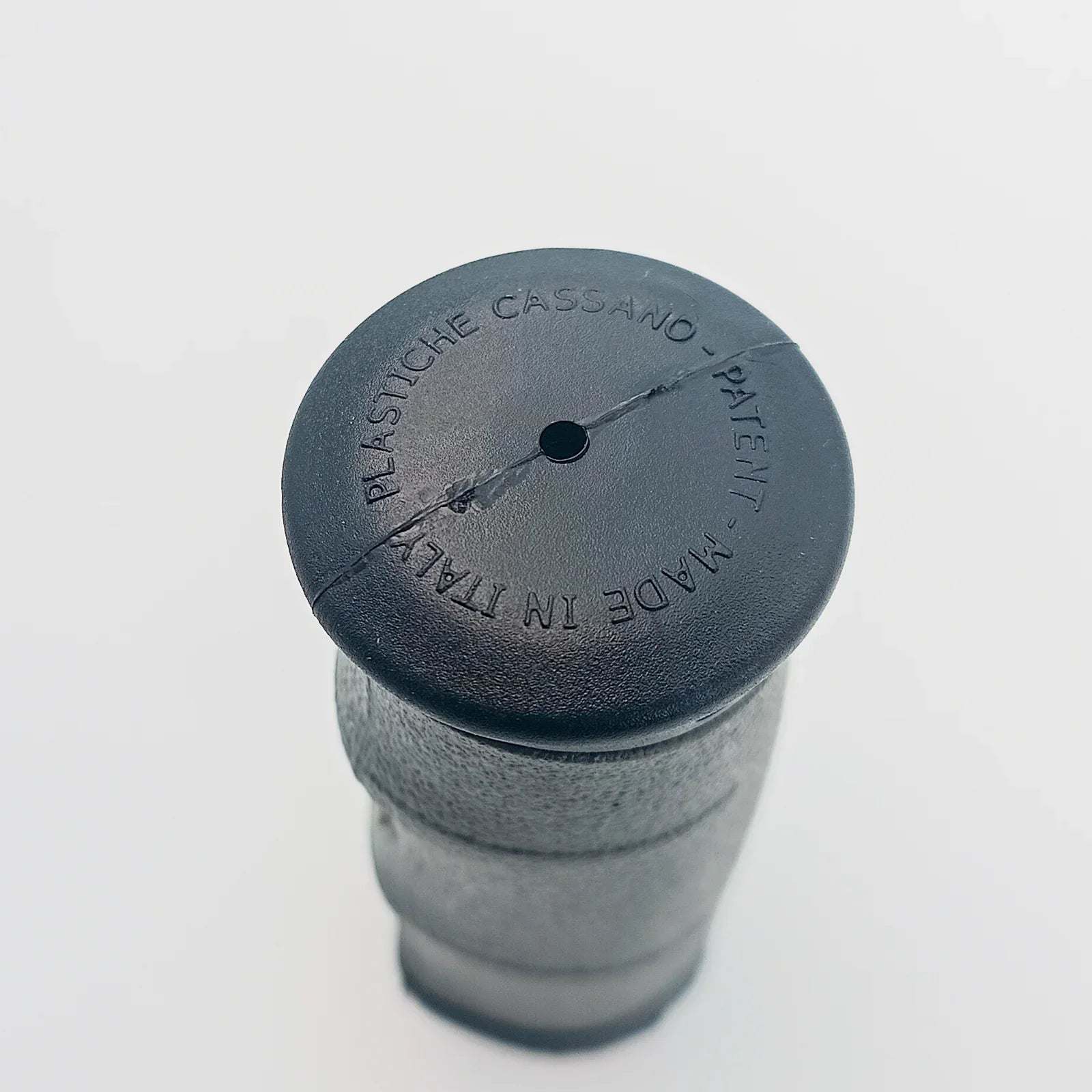 Black wheelchair accessory cap, made in Italy, with textured grip and patent marking for durable mobility parts.