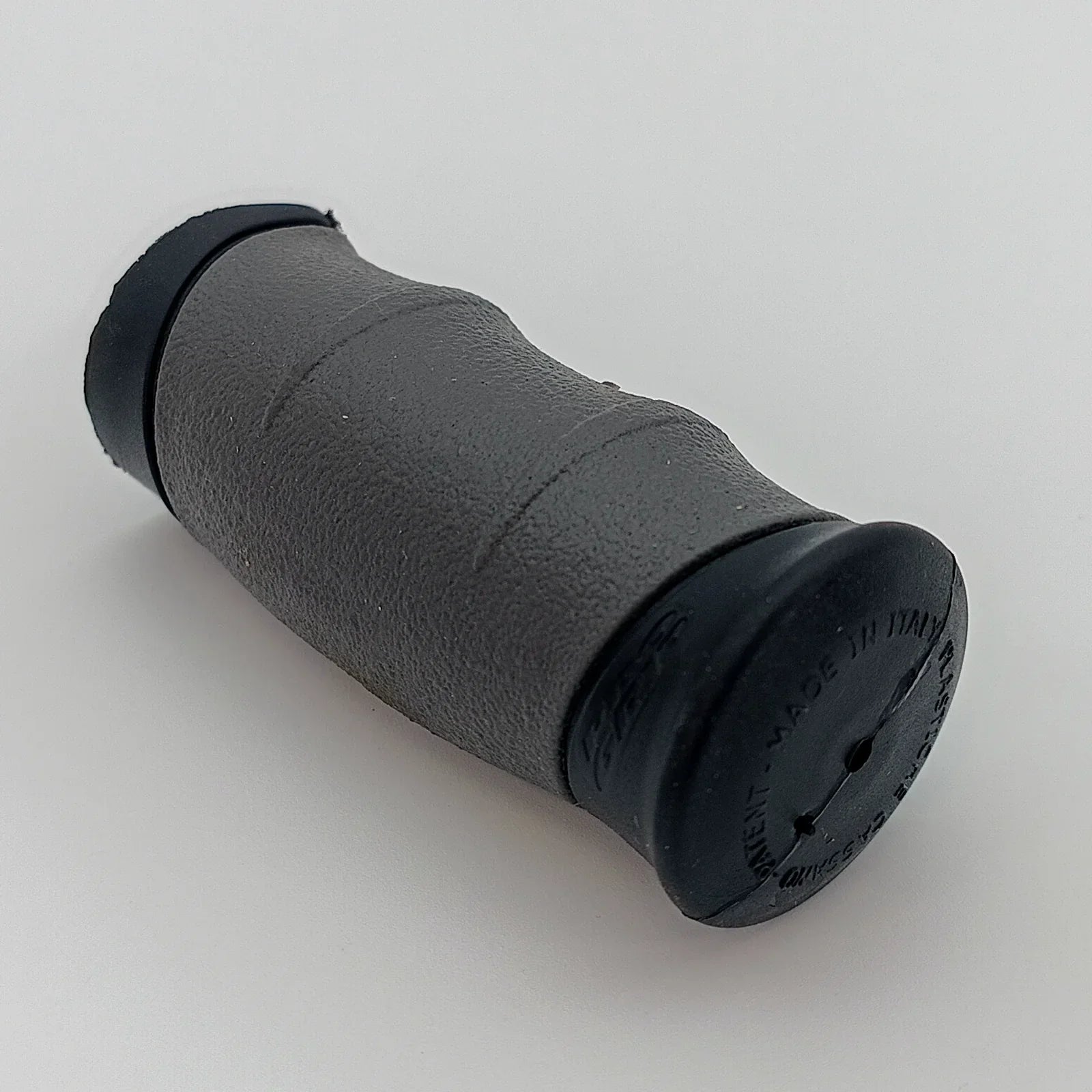 Black textured wheelchair hand grip with ergonomic design for secure push rim control