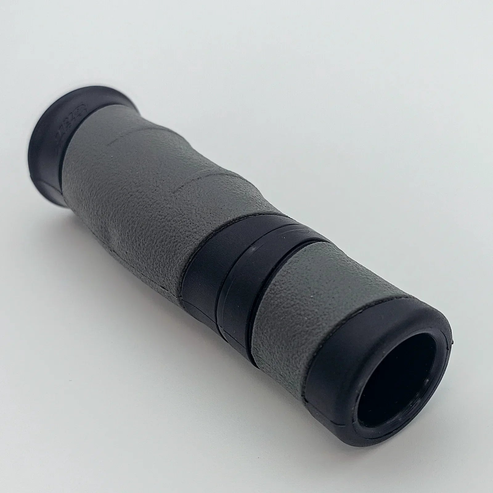 Gray and black textured wheelchair handle grip with ergonomic design for secure hold