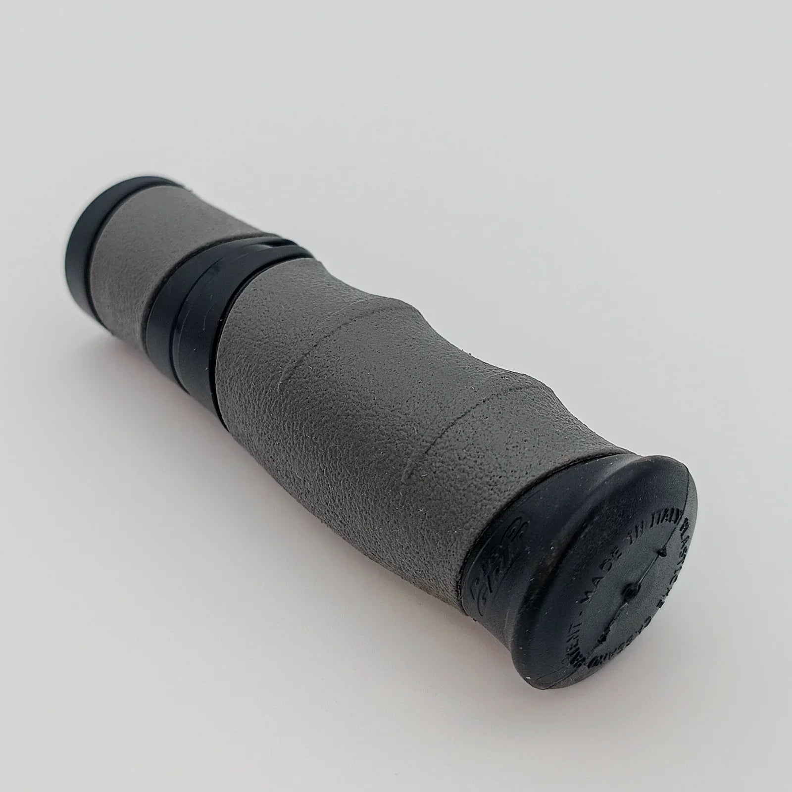 Gray textured wheelchair hand grip with black end caps, durable ergonomic design for mobility aids
