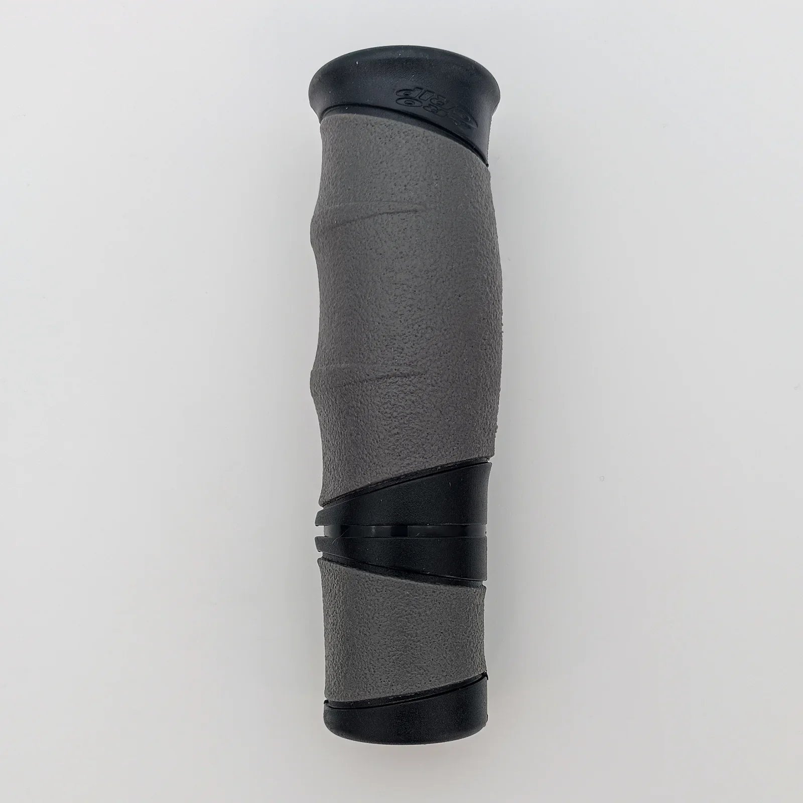 Gray and black ergonomic wheelchair hand grip with textured surface for secure hold