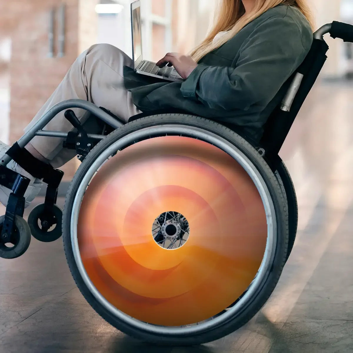 Frau im Rollstuhl mit orangefarbenem Wirbel-Speichenschutz, Rollstuhlzubehör zum Schutz