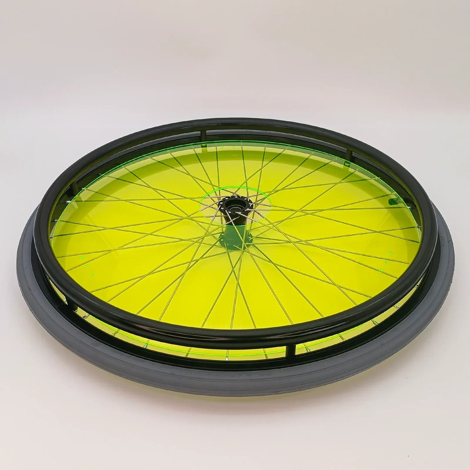 Bright yellow wheelchair spoke guard with black rim and green trim, durable accessory for wheelchair wheels