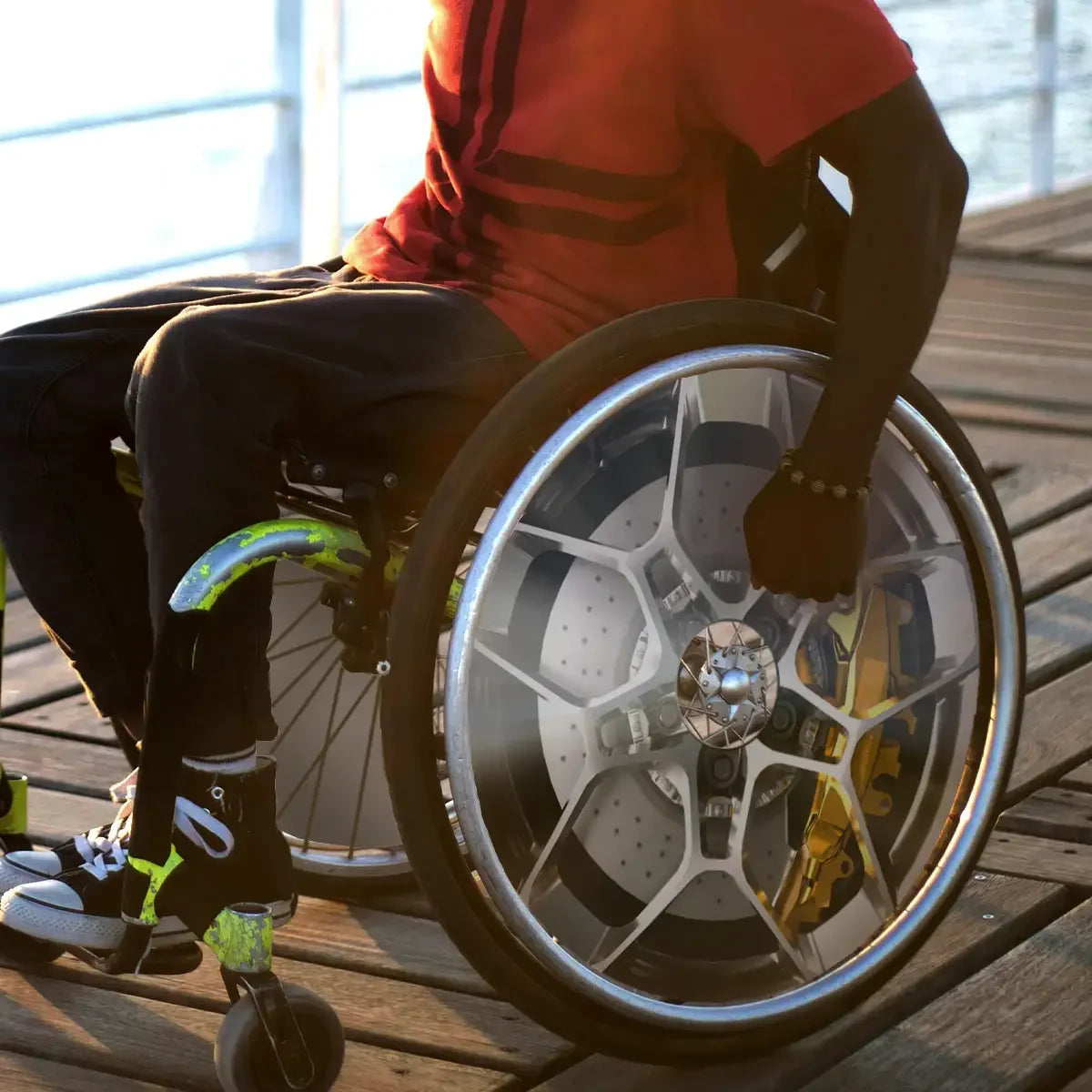 Man outdoors using wheelchair with stylish car-inspired spoke guard on wheel