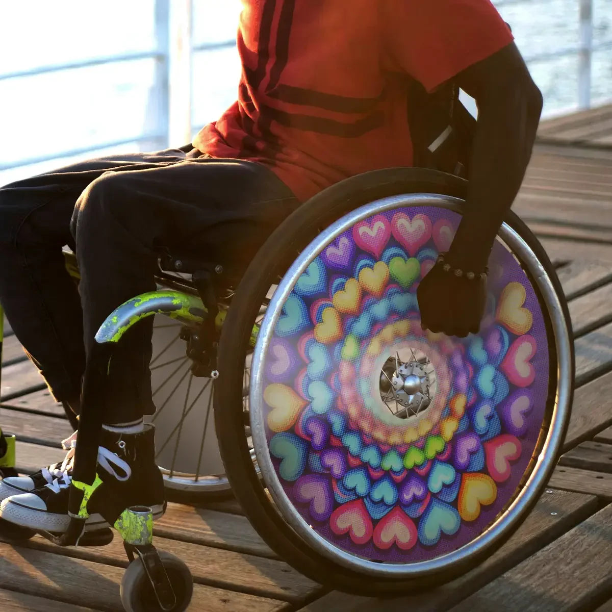 Wheelchair with vibrant spiral heart spoke guard, outdoor setting, accessibility accessory