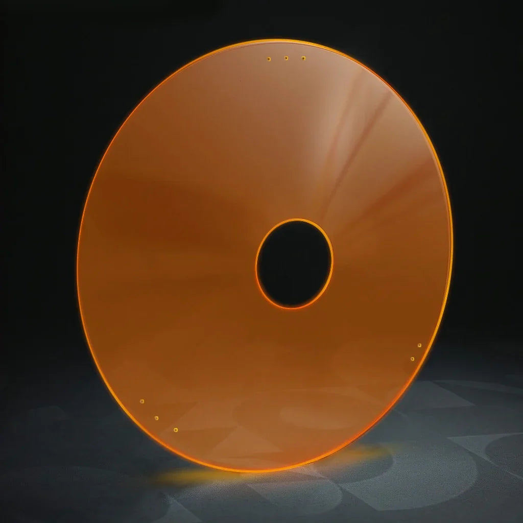 Neon orange wheelchair spoke guard with circular cutout, viewed on a dark background.