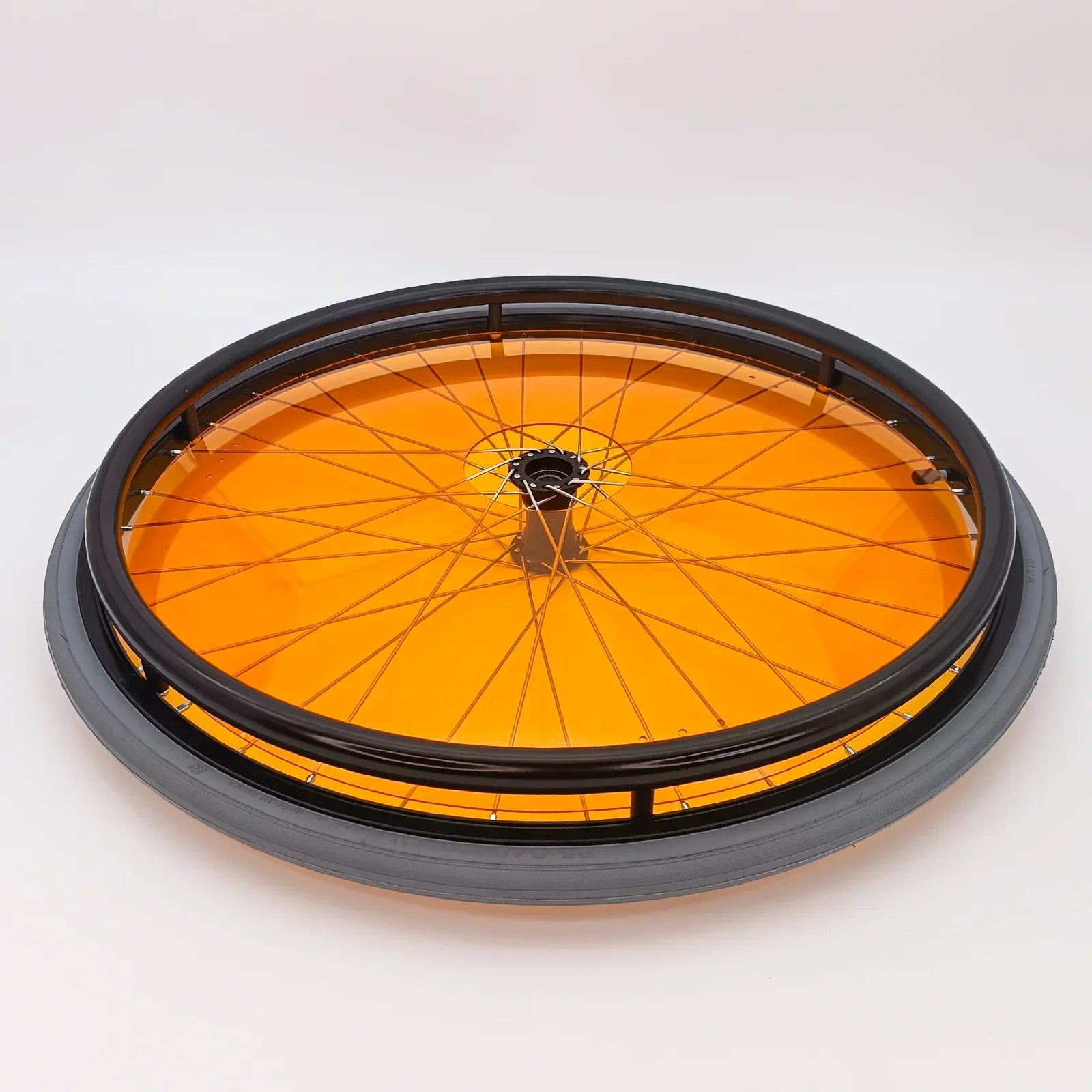 Orange wheelchair wheel with black rim and spokes, featuring durable spoke guards for safety and style.