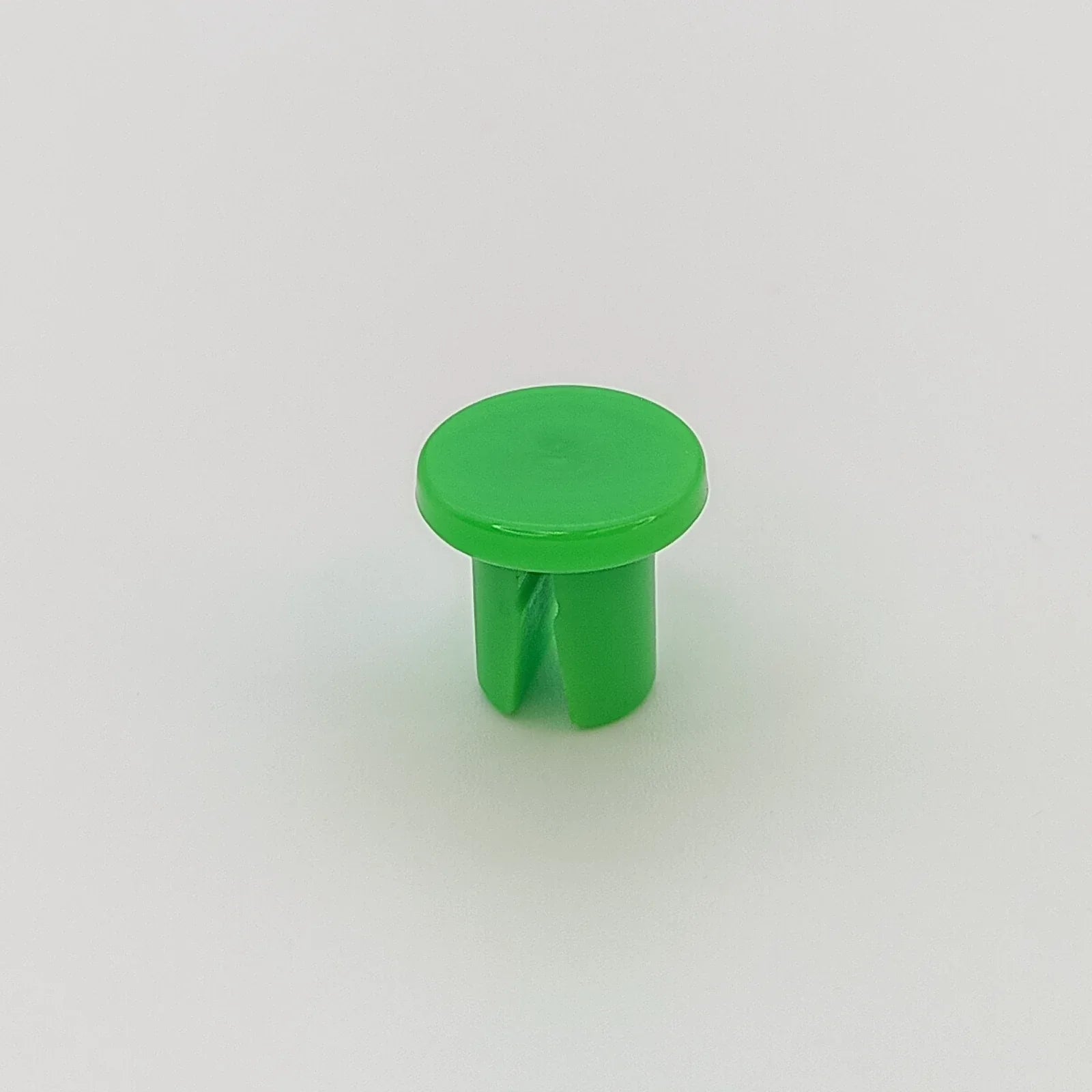 Bright green plastic wheelchair accessory cap for spoke guards or trays, durable and compact design