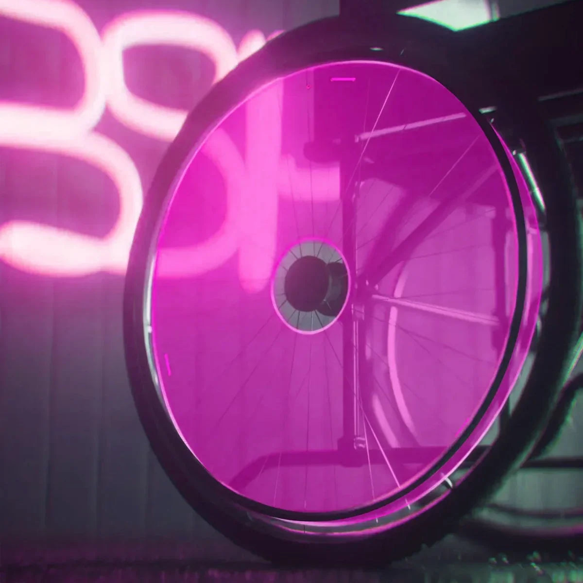 Wheelchair wheel with pink neon glow, featuring spoke guards and durable rim design for mobility accessories.