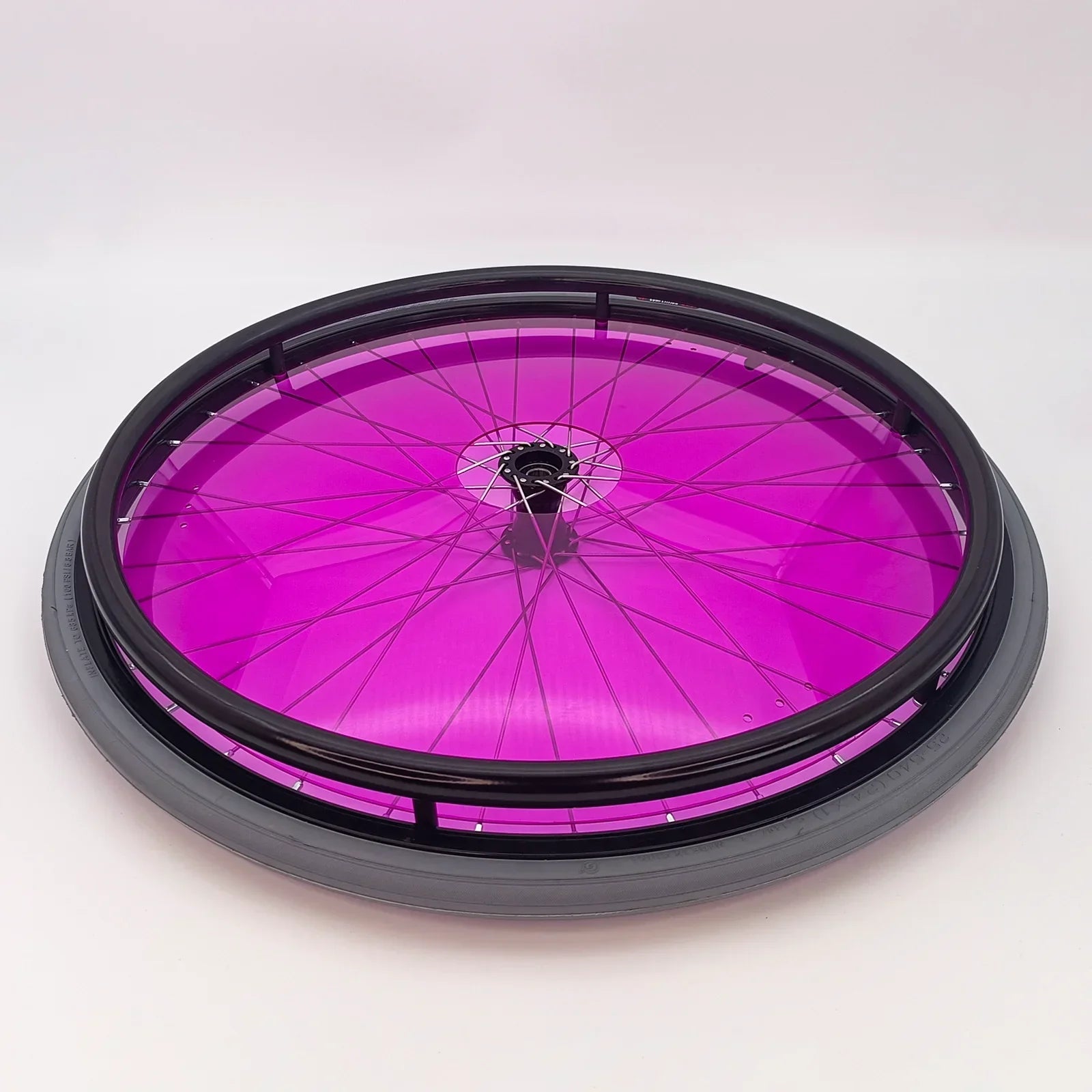 Vibrant purple wheelchair spoke guard with black rim and tire, durable accessory for mobility devices
