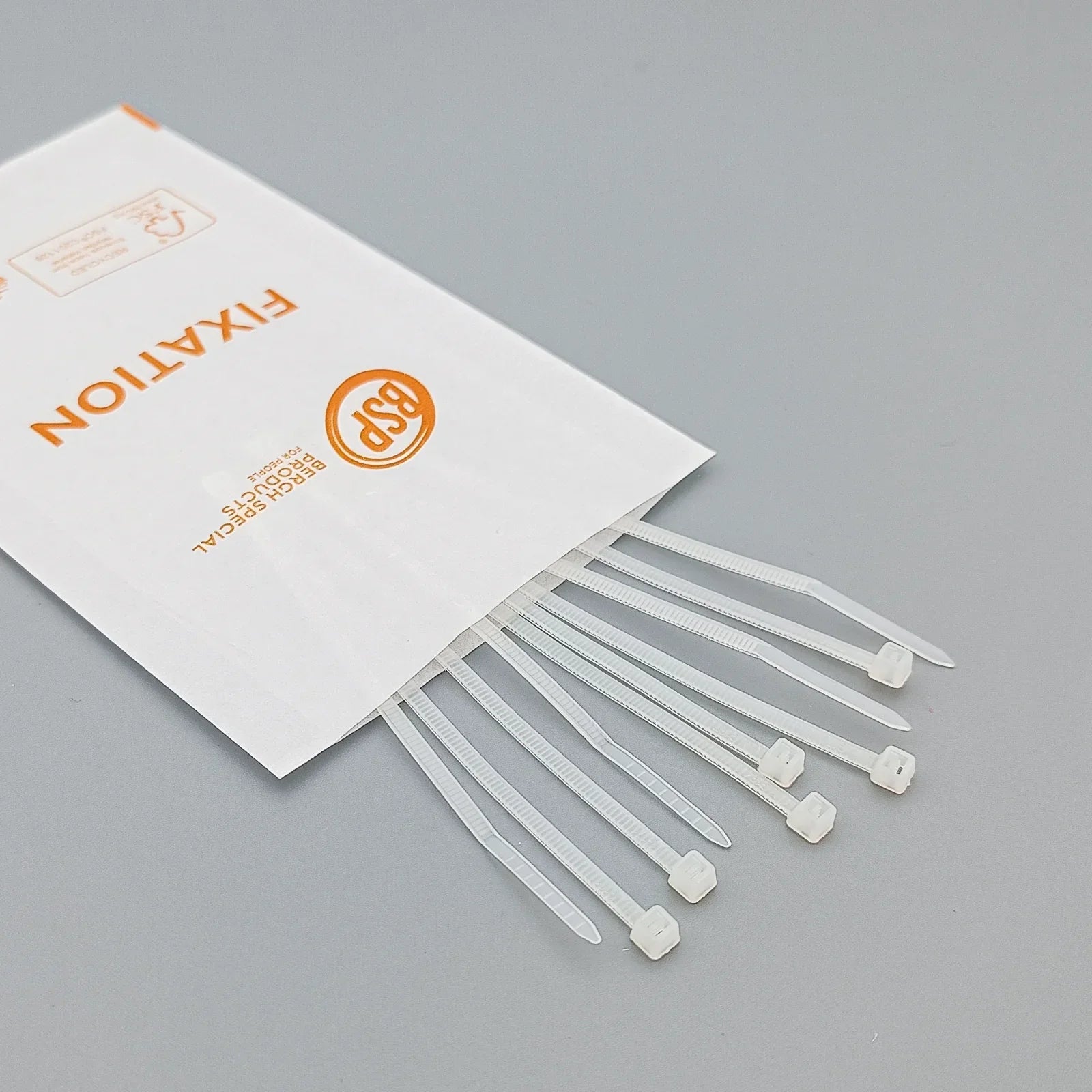 White plastic cable ties for wheelchair accessories, packaged in a BSP Fixation envelope