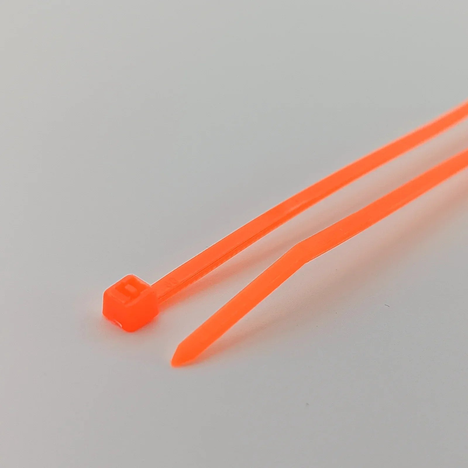 Bright orange plastic cable ties for wheelchair accessories and parts organization