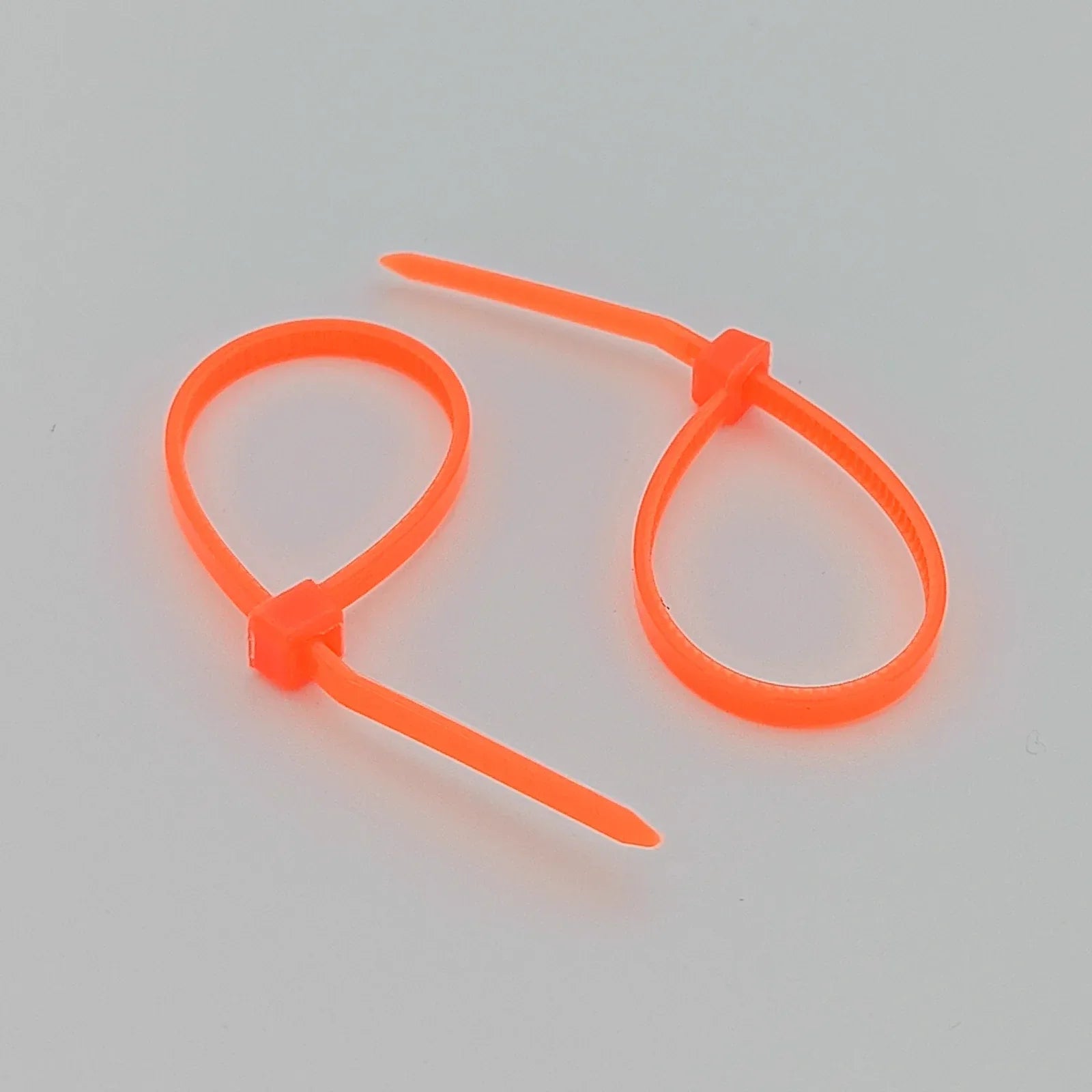 Bright orange plastic cable ties for wheelchair accessories and parts organization