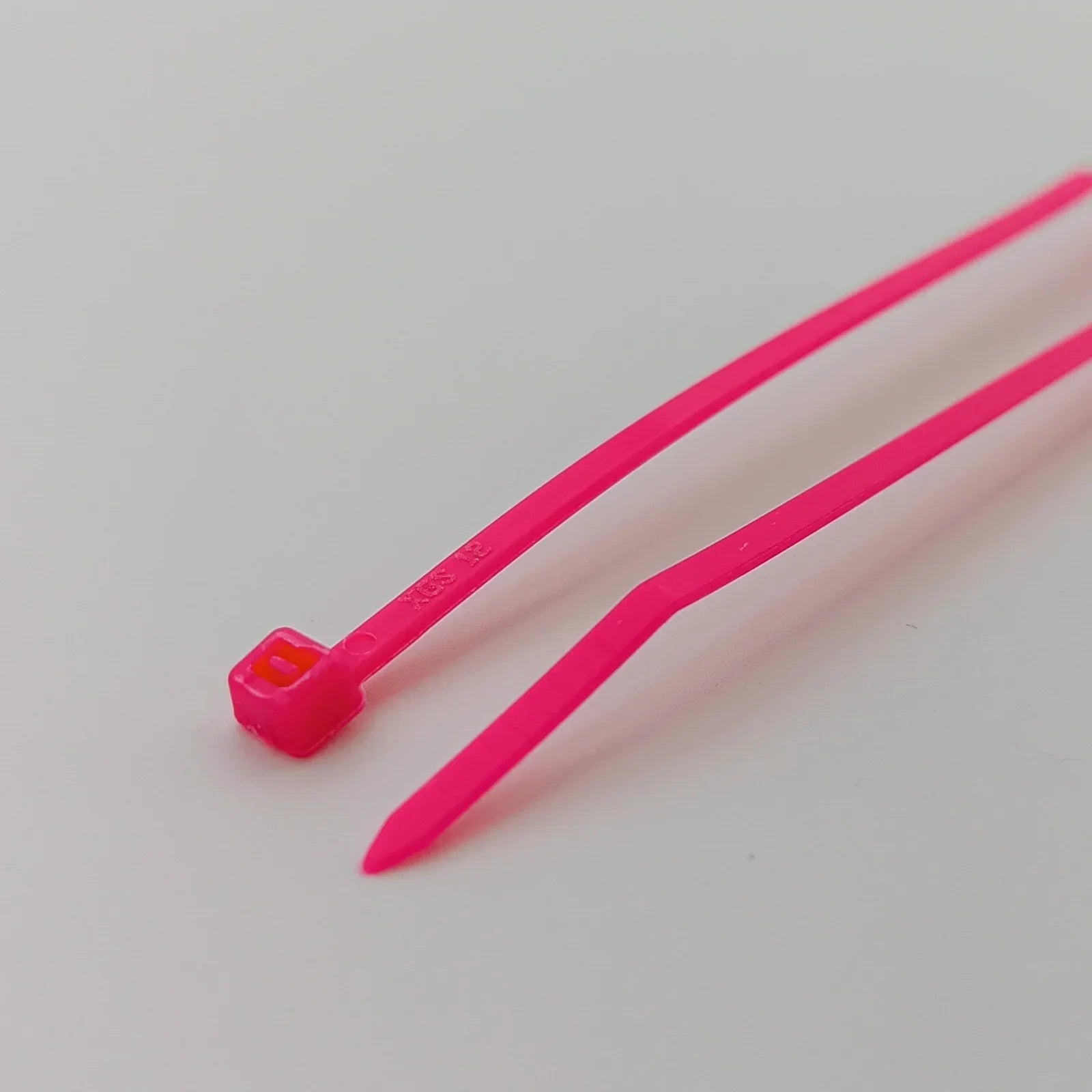 Bright pink plastic cable ties for wheelchair accessories and durable equipment organization