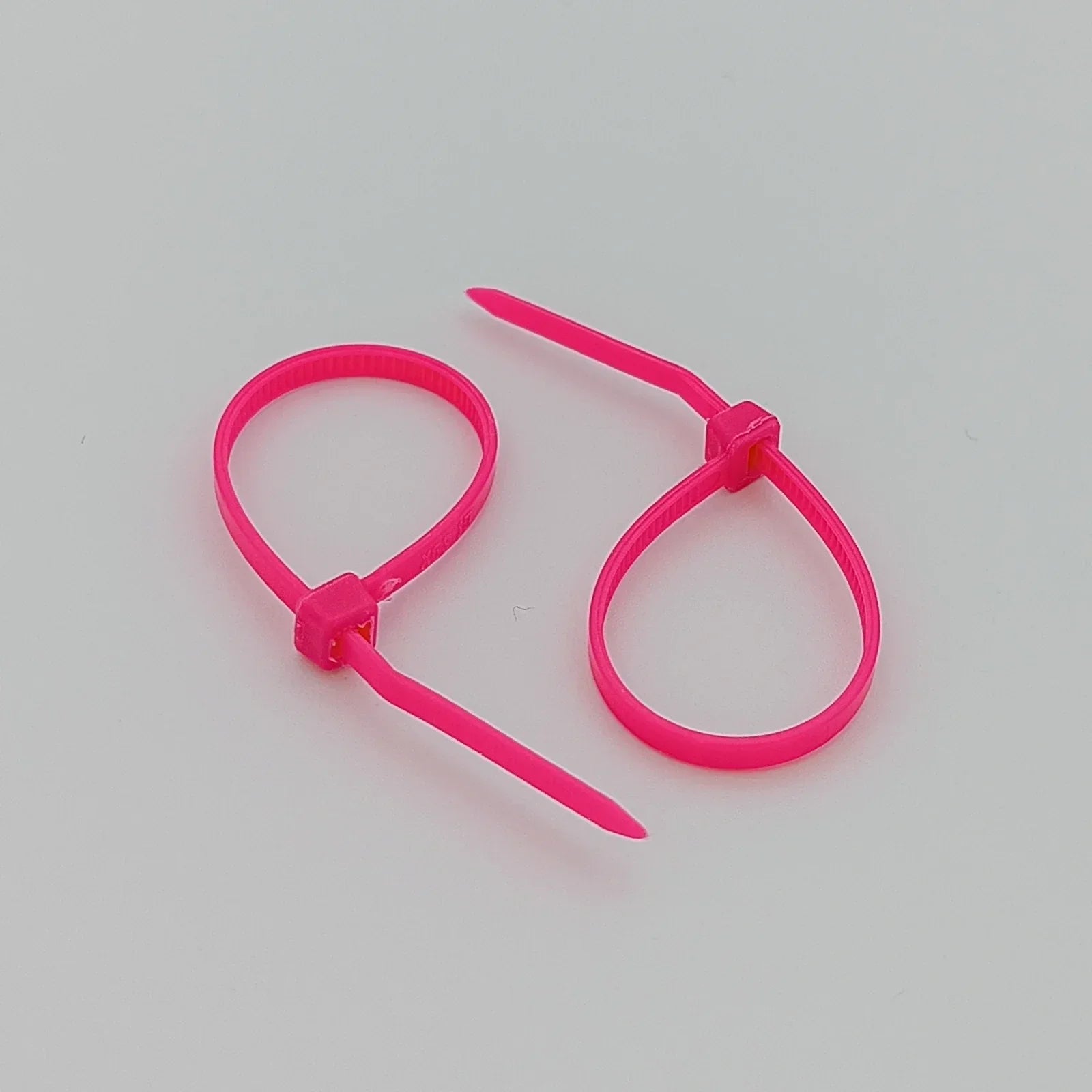 Bright pink plastic cable ties for wheelchair accessories and parts organization