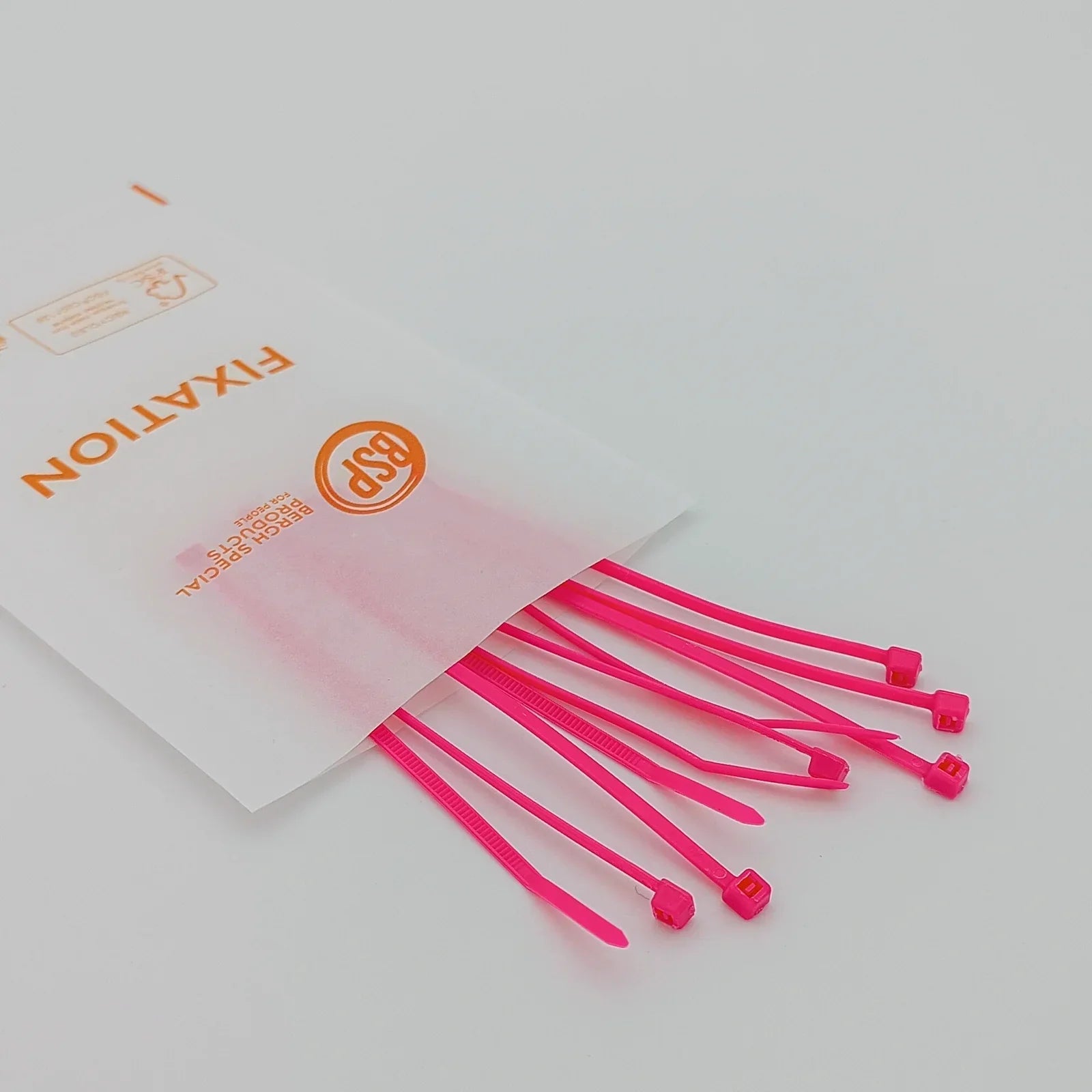 Bright pink plastic cable ties for wheelchair accessory fixation, packaged in clear BSP-branded sleeve