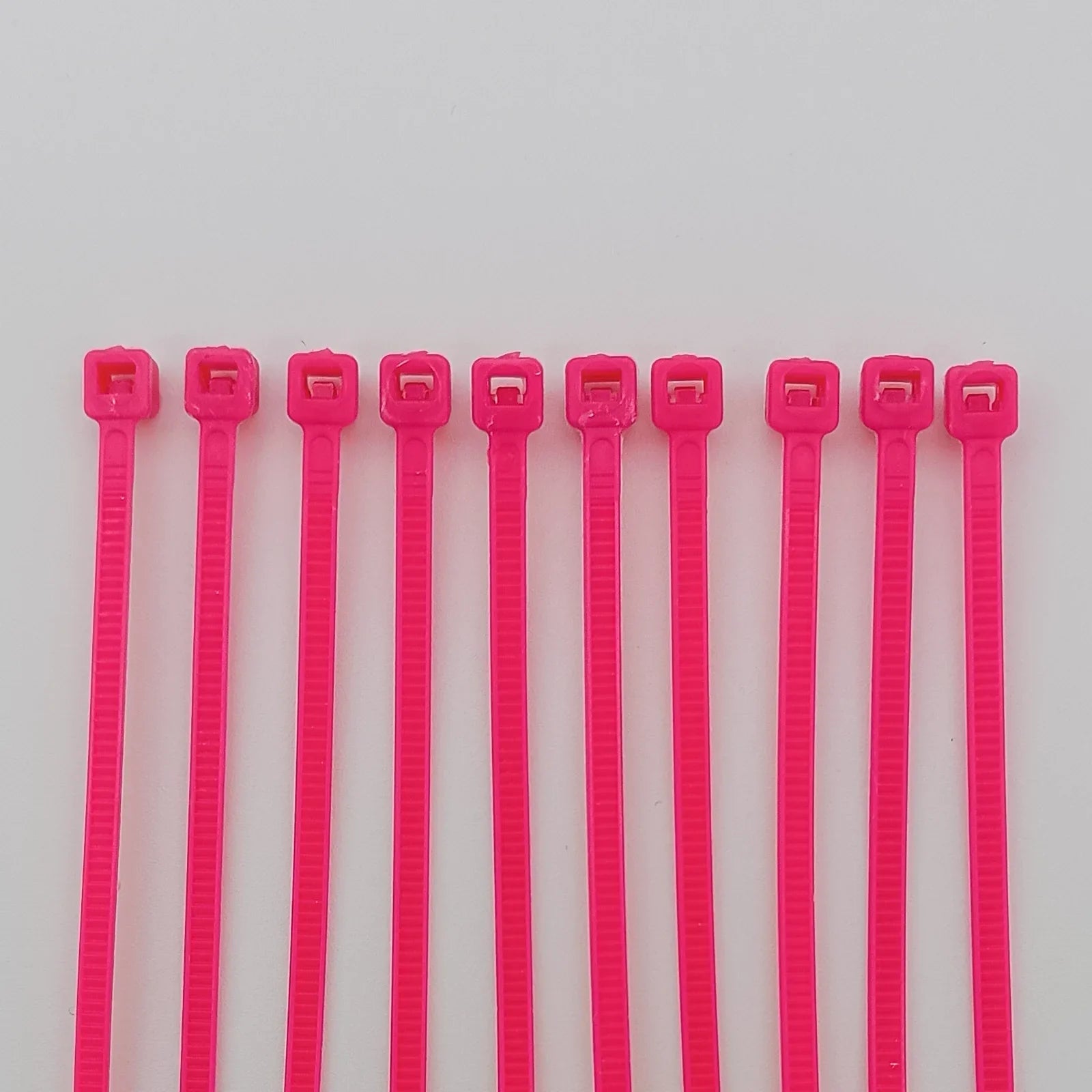 Bright pink plastic cable ties for wheelchair accessories and parts organization