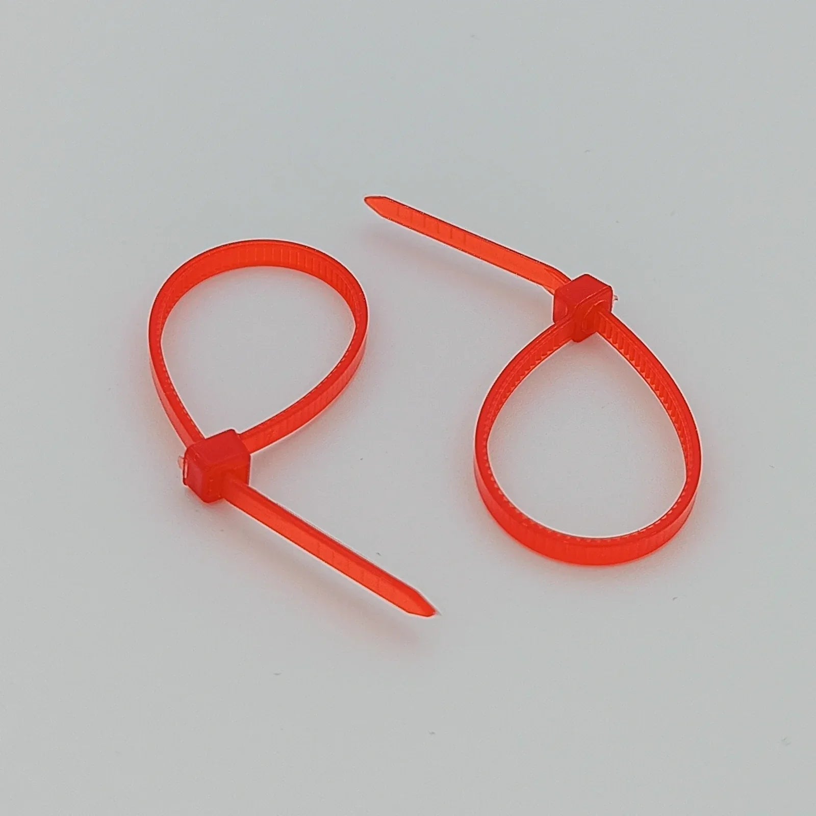 Bright orange plastic cable ties for wheelchair accessories and parts organization