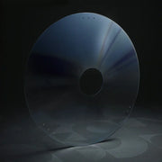 Transparent round wheelchair spoke guard with central hub hole on dark background