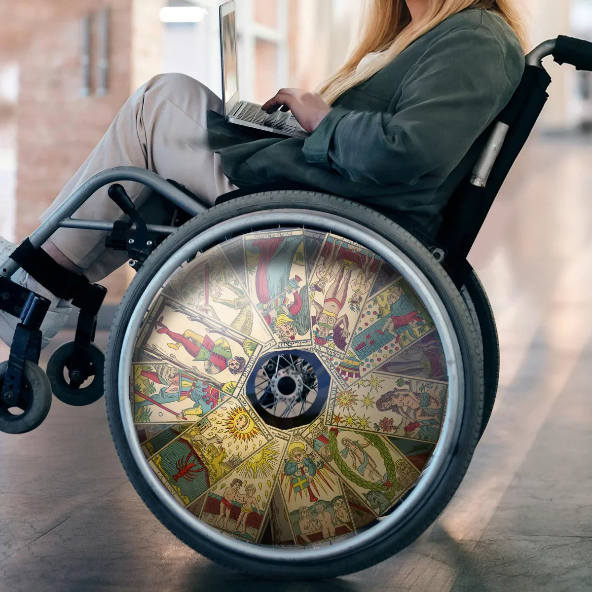 Woman in wheelchair with tarot cards spoke guard accessory, using laptop indoors
