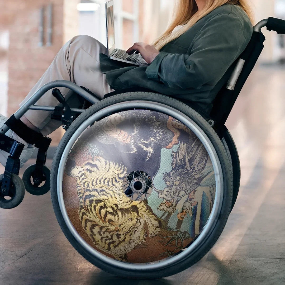 Woman using wheelchair with artistic tiger and dragon design spoke guards, indoors